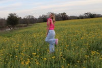 a woman standing in a field of yellow flowers